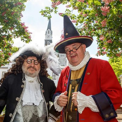 Hofnarr Joseph Fröhlich und »Zeremonienmeister« Karl von Dräsn im barocken Kostüm vor der schönen Kulisse von Schloss Burgk, wo am  19. Mai 2019 das Saturnus-Fest stattfindet.