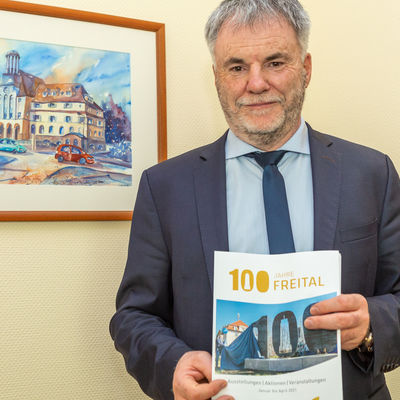 Oberbürgermeister Uwe Rumberg mit dem Programmheft Januar bis April 2021 zu »100 Jahre Freital« 
