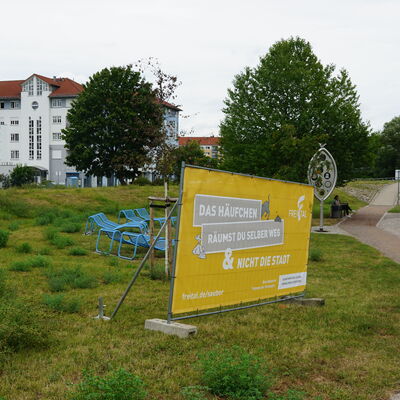 In Freitaler Parks, wie hier im Windbergpark, sind Banner aufgestellt, um auf das Thema Hundekot aufmerksam zu machen.