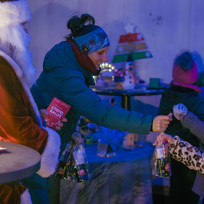 Der Weihnachtsmann &uuml;bergibt kleine Geschenke an die Kinder, die an der Rallye teilgenommen haben