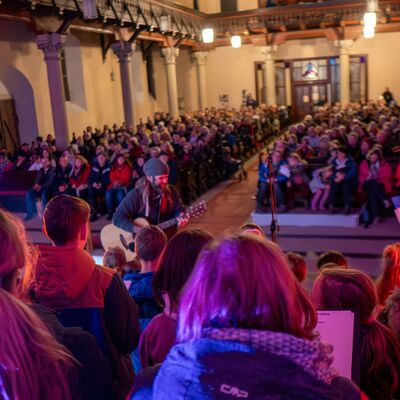 In einer Kirche singen Menschen Weihnachtslieder